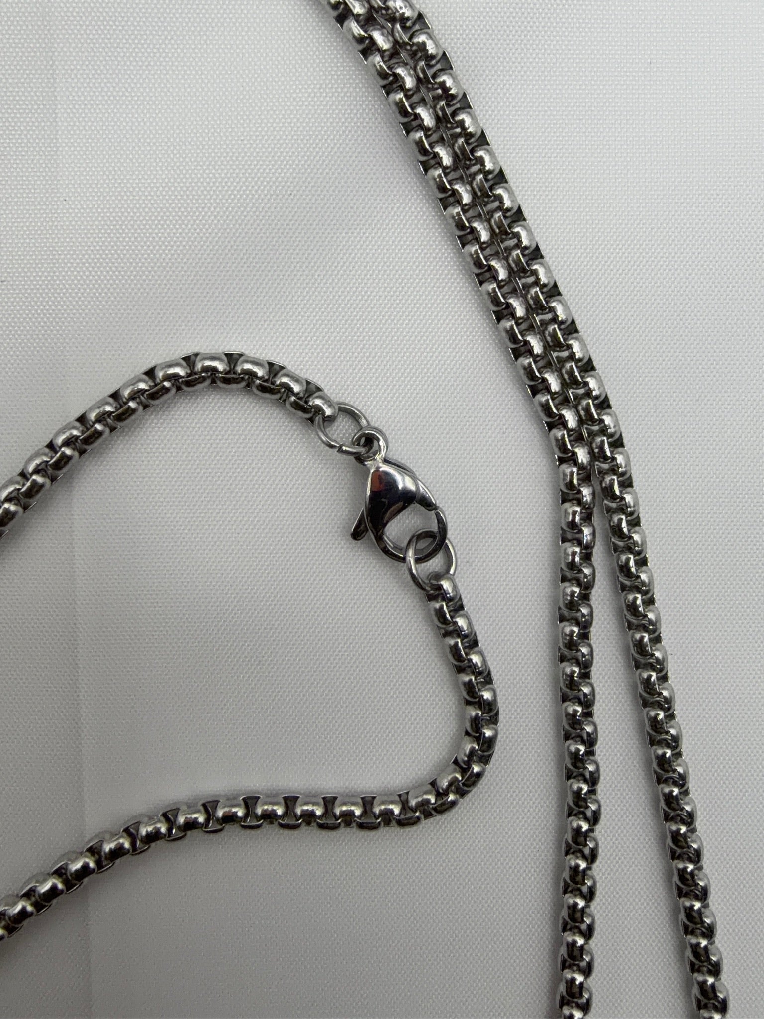 Close-up of silver box chain with lobster clasp