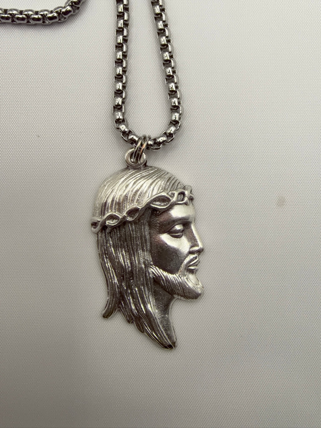 Jesus pendant close-up, silver stainless steel, crown of thorns detail, made in Italy
