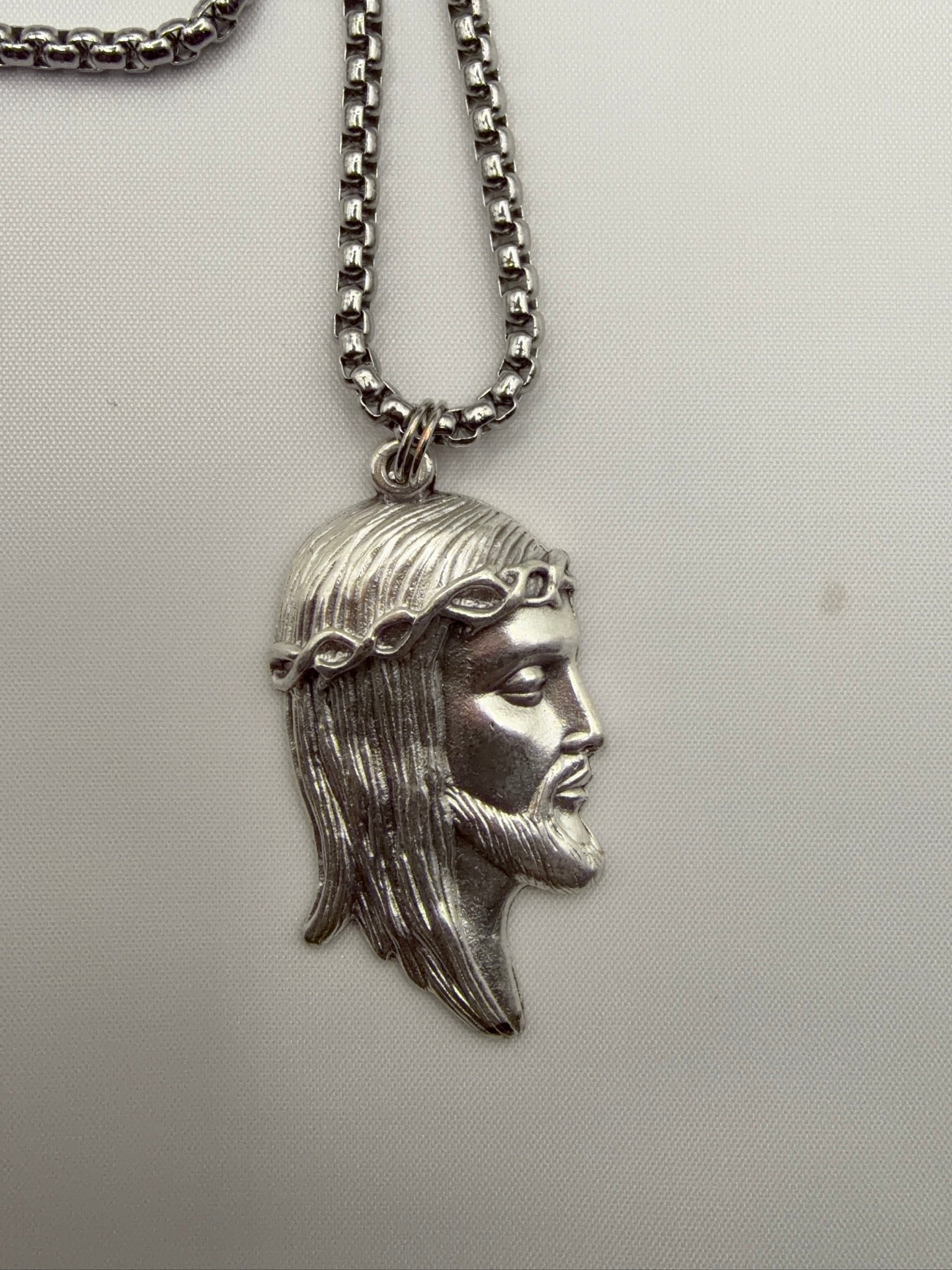 Jesus pendant close-up, silver stainless steel, crown of thorns detail, made in Italy